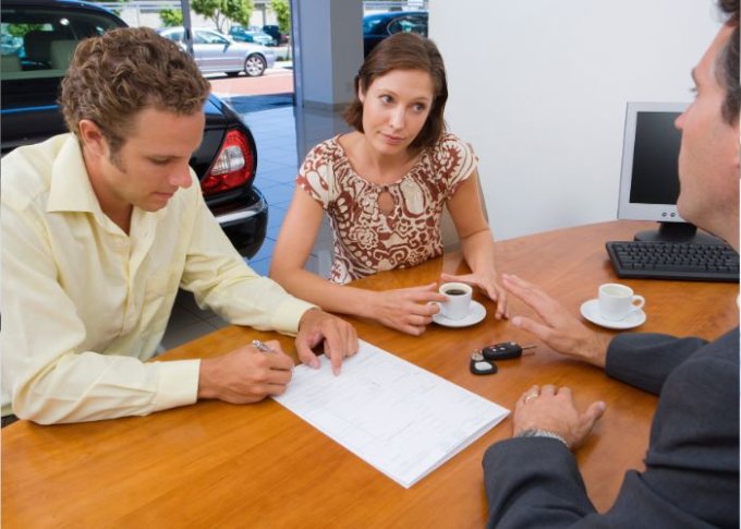 Kobieta i mężczyzna rozmawiają na temat korzyści leasingu samochodowego ze sprzedawcą